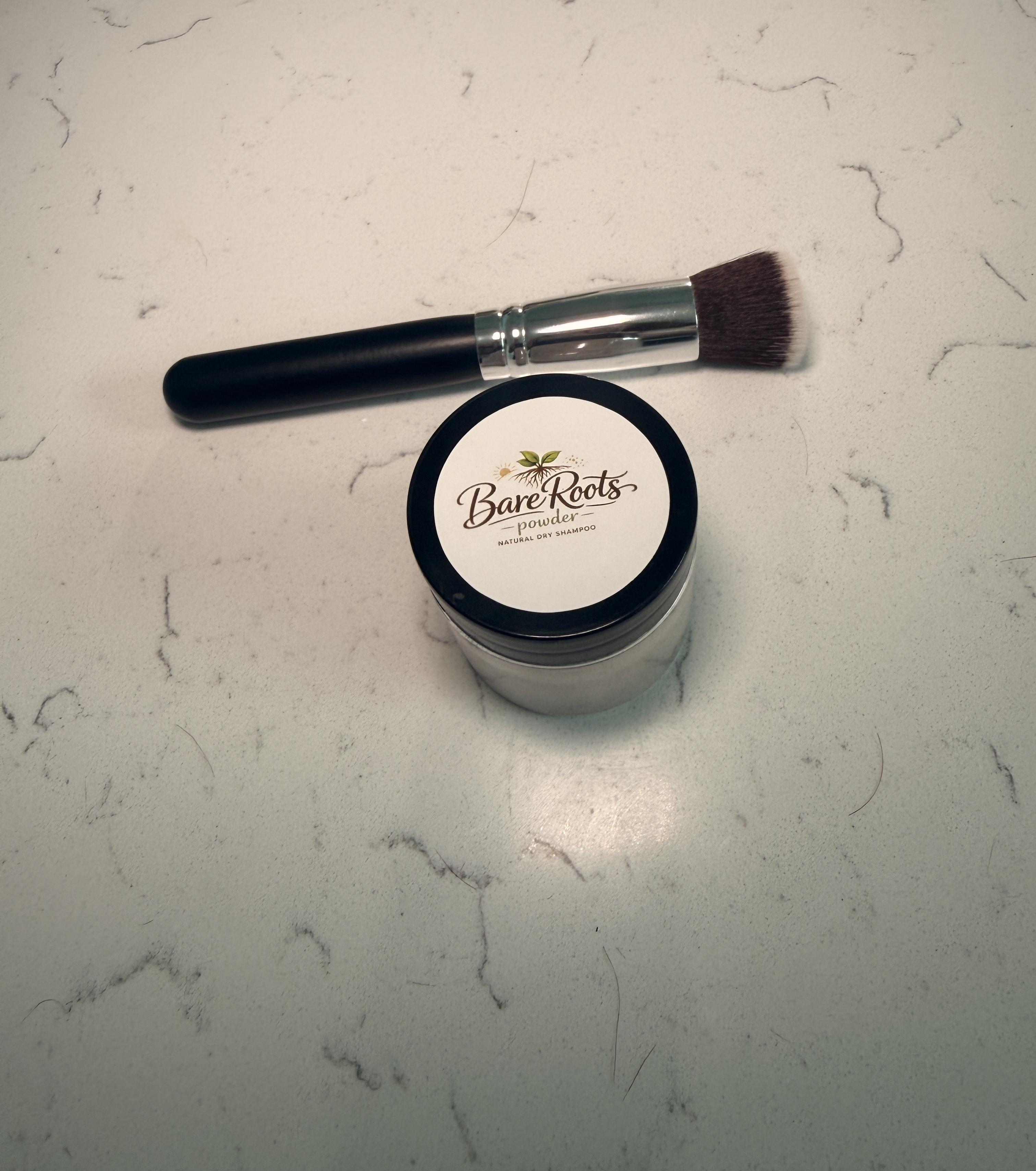 BareRoots founder holding product and brush